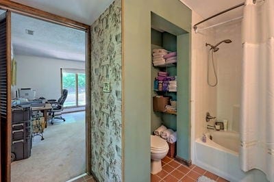 bathroom with tile patterned flooring, toilet, and shower / tub combo