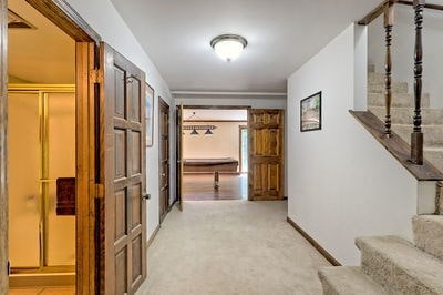 corridor featuring light colored carpet