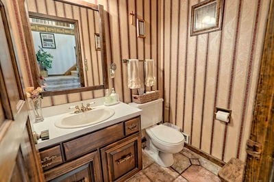 bathroom with tile patterned flooring, vanity, and toilet