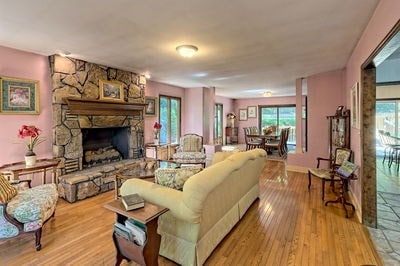 living room featuring a stone fireplace and light hardwood / wood-style floors