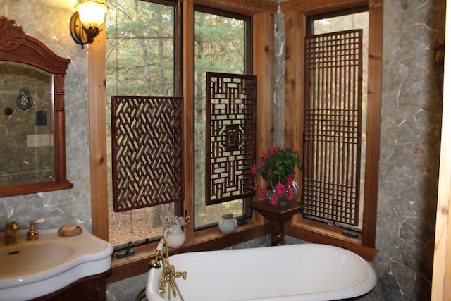 bathroom featuring vanity and a washtub