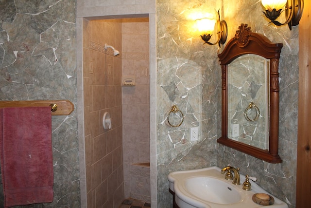 bathroom featuring sink and tile walls