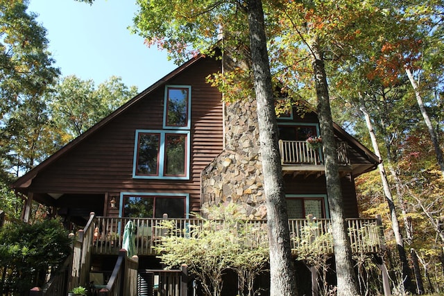 view of home's exterior with a wooden deck and a balcony