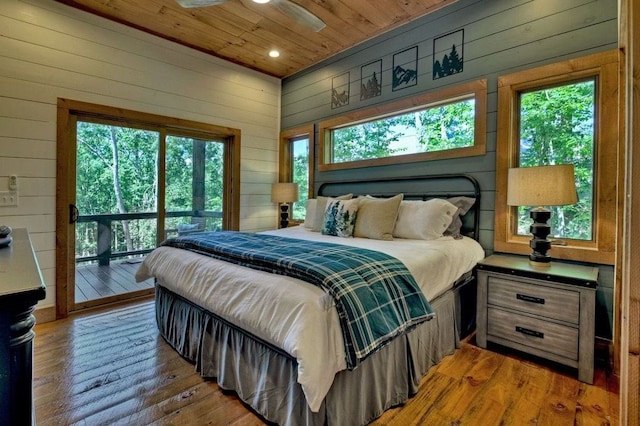 bedroom featuring wood-type flooring, access to exterior, wooden walls, and wood ceiling