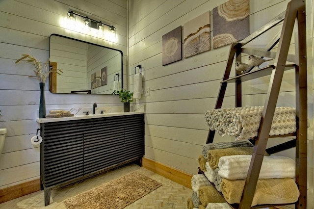 bathroom with vanity, parquet flooring, and wooden walls