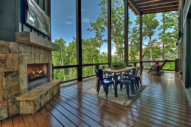 sunroom featuring a wealth of natural light and an outdoor stone fireplace