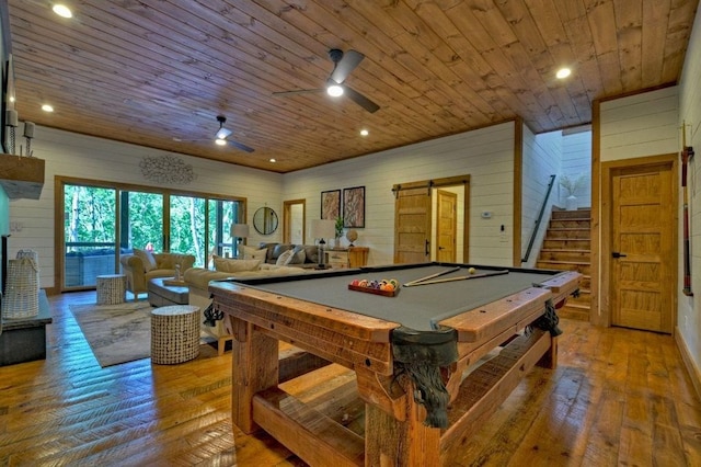 recreation room with wood ceiling, hardwood / wood-style flooring, wooden walls, and a barn door