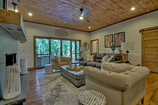 living room with a barn door, wooden walls, parquet floors, and wood ceiling