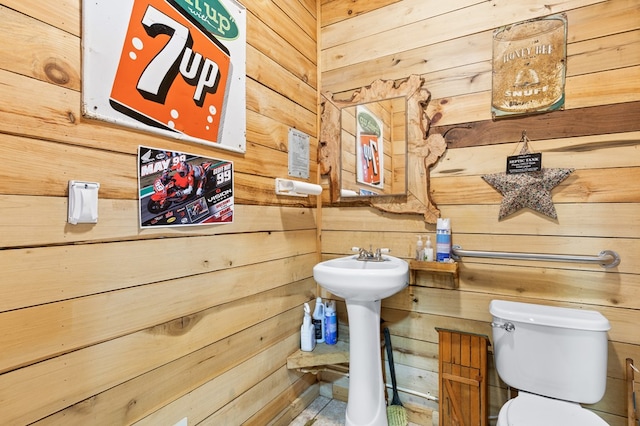 bathroom featuring wooden walls and toilet