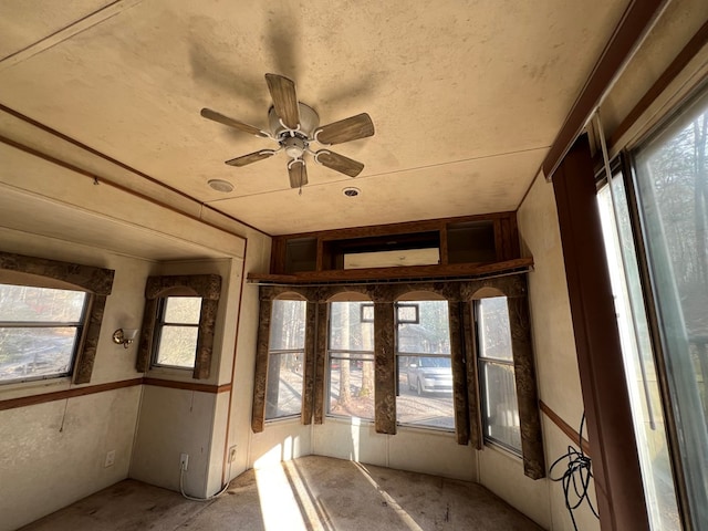 unfurnished sunroom featuring a ceiling fan