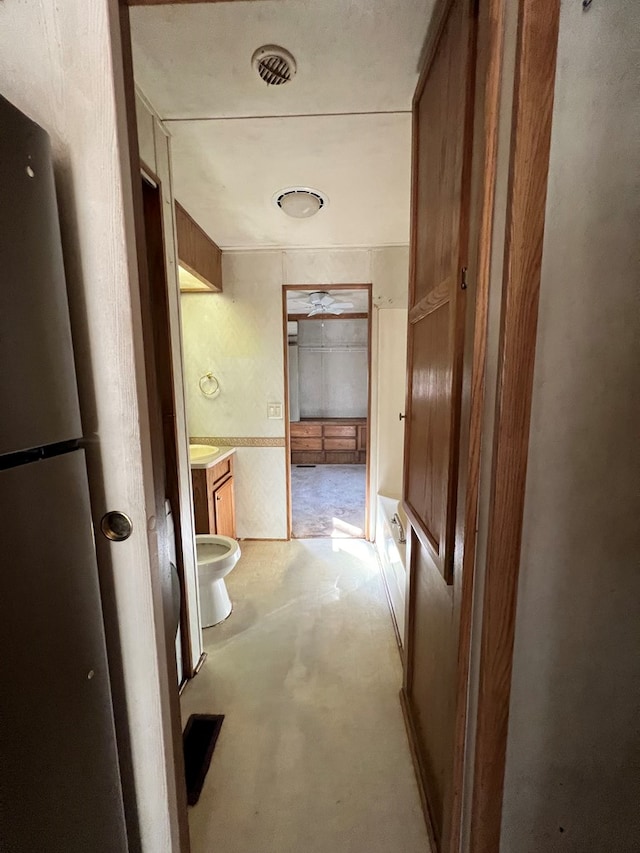 corridor with visible vents and concrete flooring