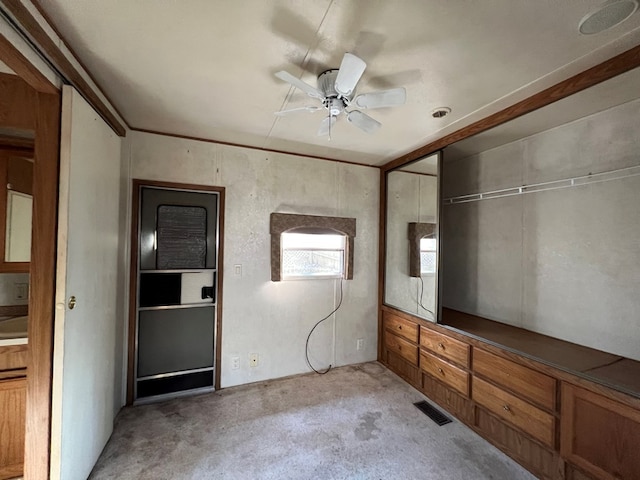 unfurnished bedroom featuring a closet, visible vents, light colored carpet, and a ceiling fan