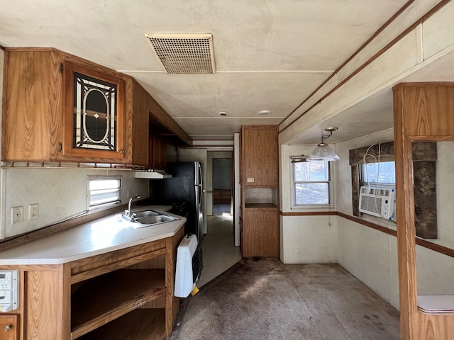 kitchen featuring a healthy amount of sunlight, brown cabinets, and a sink