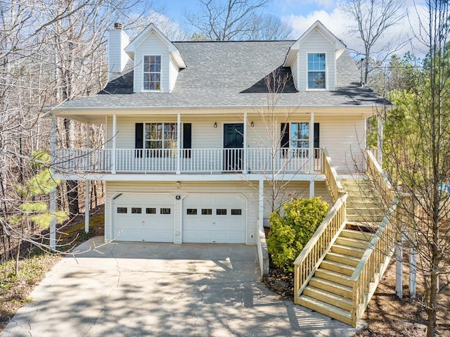 view of front of home featuring a chimney, covered porch, a garage, driveway, and stairs