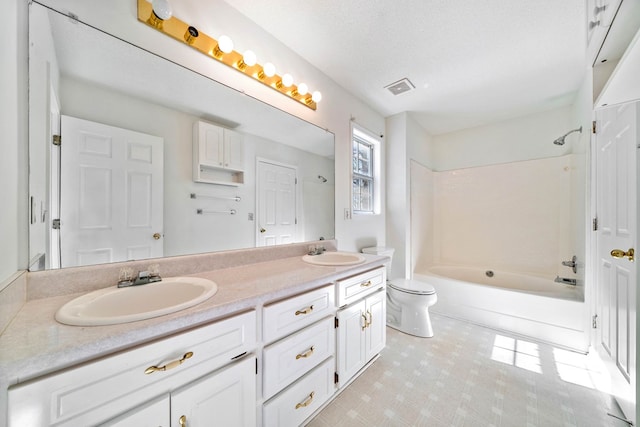 full bath with visible vents, double vanity, a sink, and toilet