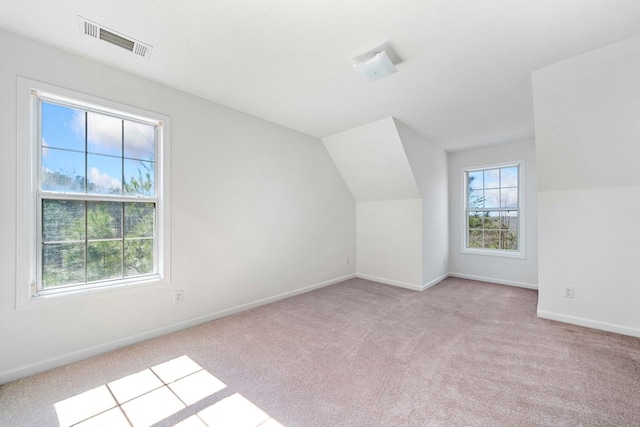 bonus room featuring lofted ceiling, carpet flooring, visible vents, and baseboards