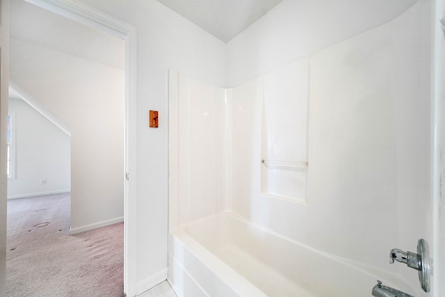 bathroom with shower / bathtub combination, a textured ceiling, and baseboards