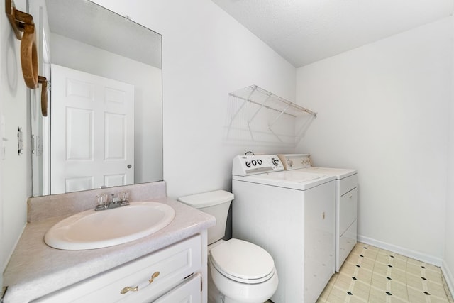 bathroom featuring toilet, tile patterned floors, washing machine and clothes dryer, a textured ceiling, and vanity