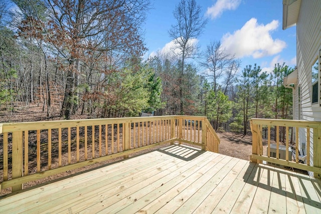 wooden terrace featuring a wooded view