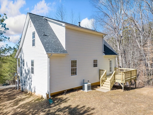 rear view of house with a shingled roof, stairs, cooling unit, and a wooden deck