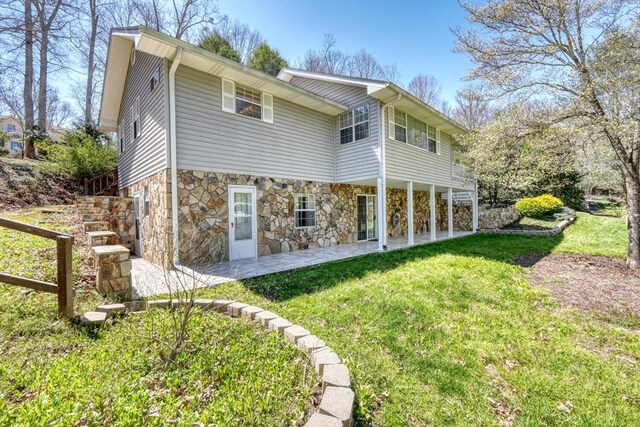 back of house with a lawn and a patio area