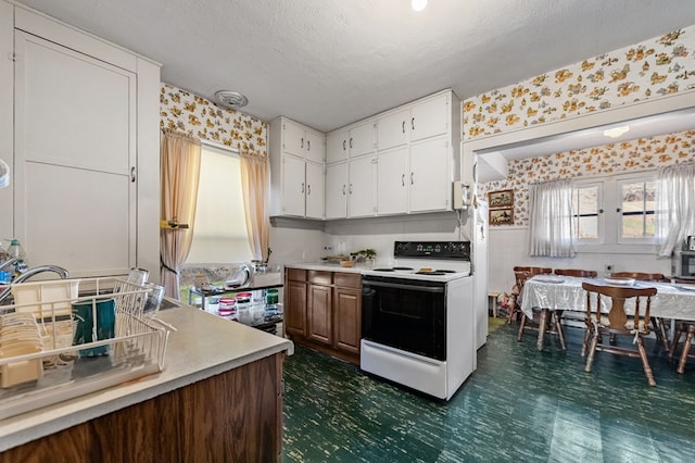 134 Church St, Copperhill, TN 37317 - kitchen with electric range, white cabinets, and a textured ceiling