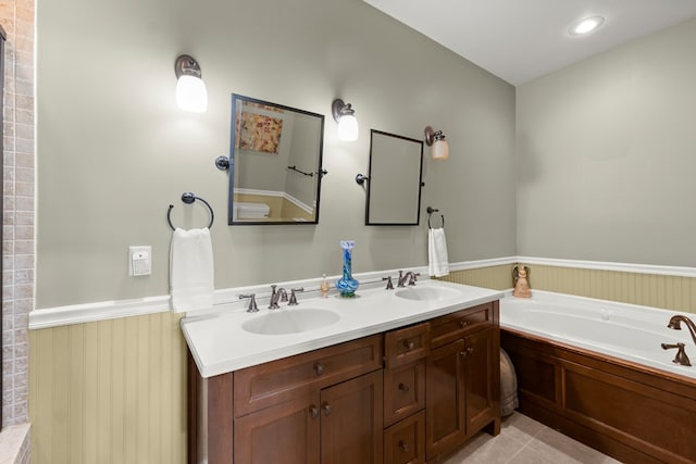 bathroom with tile patterned floors, a bathing tub, and vanity