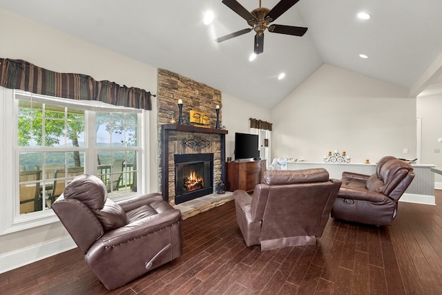 living room featuring ceiling fan, lofted ceiling, hardwood / wood-style floors, and a stone fireplace