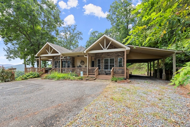 view of front of house featuring covered porch, a mountain view, and a carport