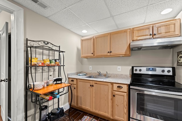 kitchen with stainless steel electric range oven, sink, a drop ceiling, and light brown cabinets