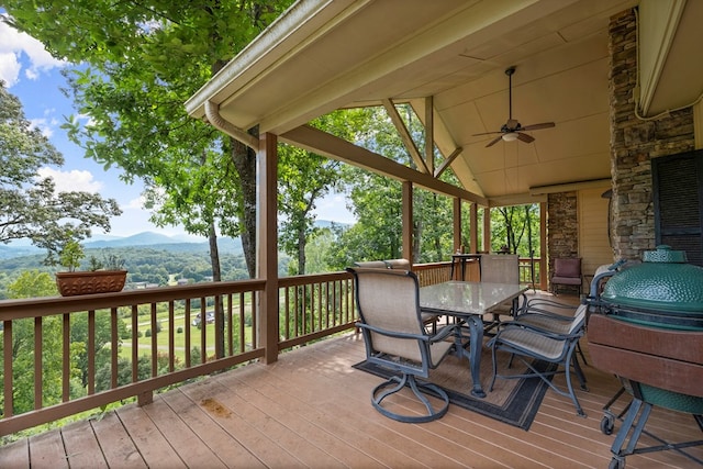 wooden terrace with a mountain view, ceiling fan, and grilling area