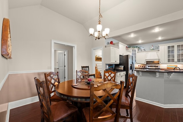 dining room featuring dark hardwood / wood-style flooring, a notable chandelier, sink, and lofted ceiling