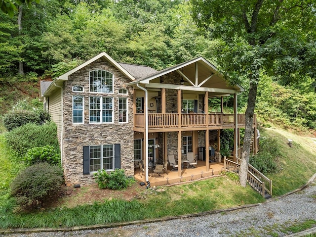 view of front of property with a wooden deck and a patio