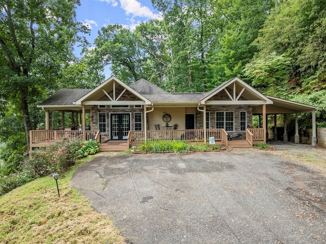 view of front of property featuring french doors, a porch, and a carport