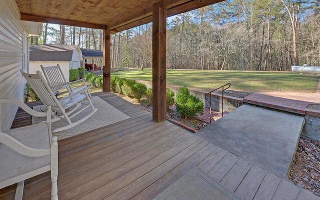 wooden terrace featuring a lawn and a porch