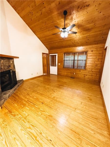 unfurnished living room featuring a ceiling fan, wood ceiling, lofted ceiling, and wood finished floors