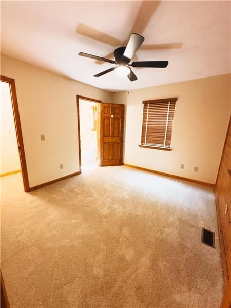 unfurnished room featuring baseboards, ceiling fan, visible vents, and light carpet