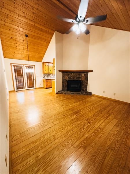 unfurnished living room featuring wood finished floors, lofted ceiling, a fireplace, ceiling fan, and wooden ceiling