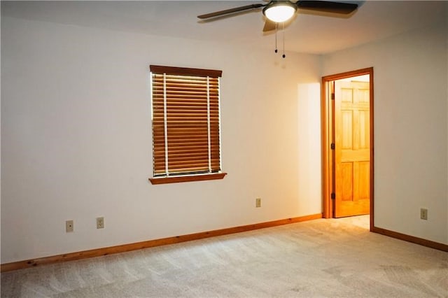 unfurnished room with baseboards, a ceiling fan, and light colored carpet