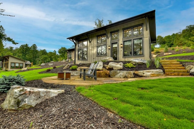 back of house with a yard and a patio