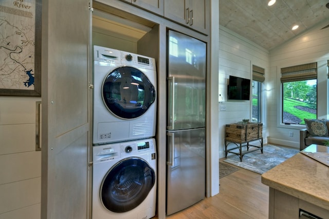 laundry area with stacked washer and dryer, wood ceiling, and light hardwood / wood-style flooring