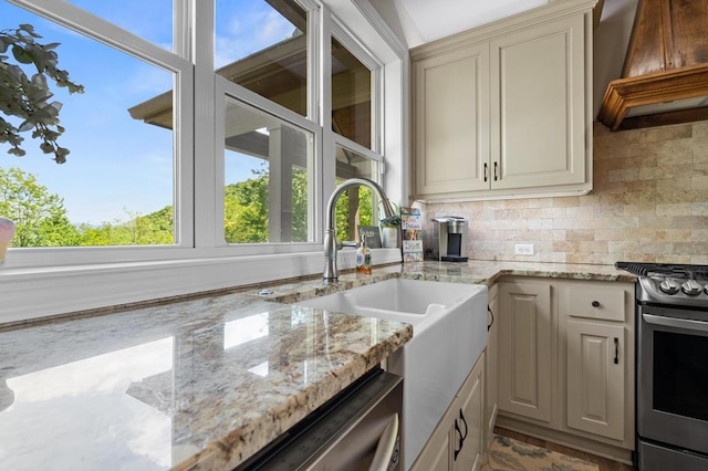 kitchen featuring stainless steel appliances, premium range hood, a sink, backsplash, and light stone counters
