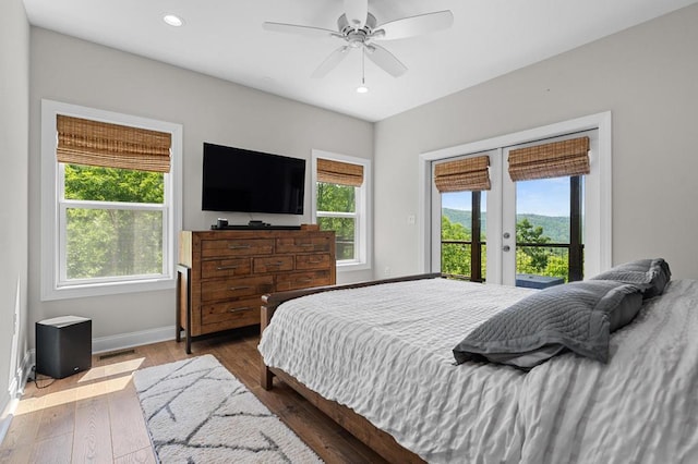 bedroom with access to exterior, baseboards, recessed lighting, wood finished floors, and french doors