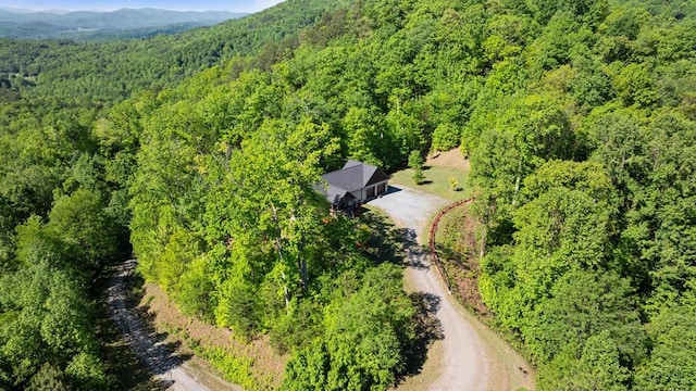 aerial view of property's location featuring a forest and mountains