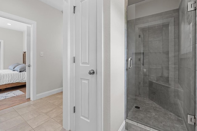full bathroom featuring a stall shower, tile patterned floors, ensuite bathroom, and baseboards