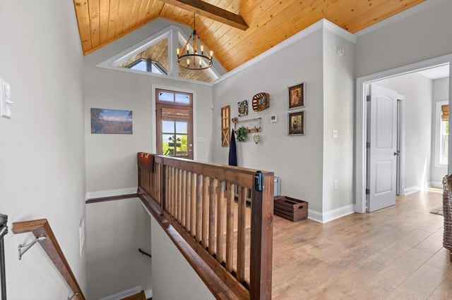 stairway with wood ceiling, a chandelier, wood finished floors, vaulted ceiling, and baseboards