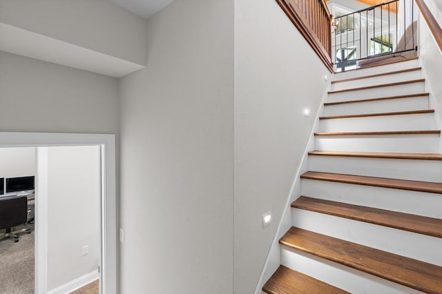 stairs featuring baseboards and carpet flooring