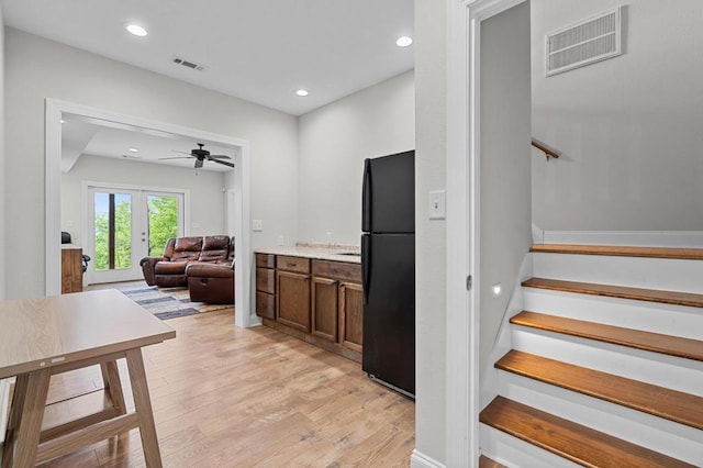 staircase with wood finished floors, ceiling fan, french doors, and recessed lighting