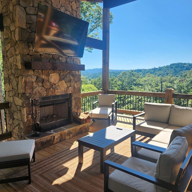 wooden terrace featuring an outdoor living space with a fireplace
