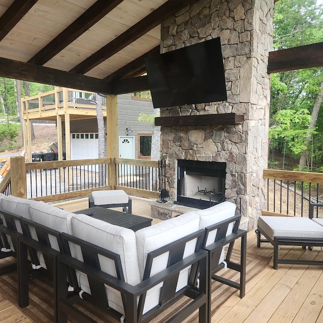 wooden terrace with an outdoor living space with a fireplace